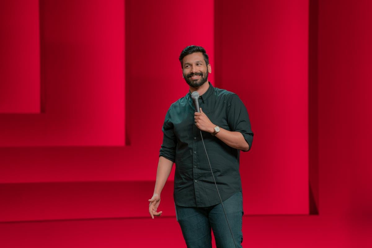 Kanan Gill holding a microphone on stage